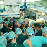 An image of Dr. Carey in an operating room with other doctors