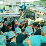 Dr. Carey and a crowd of doctors and nurses in an operating room